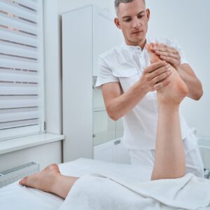 Experienced concentrated physiotherapist using an acupressure massage